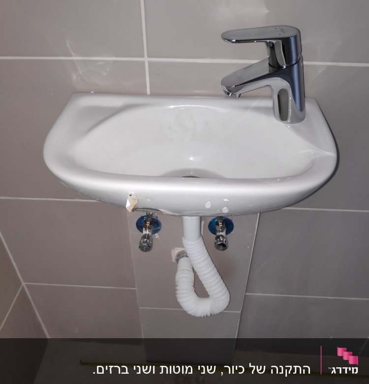 כיור עם ברז וכלי עבודה על הרצפה